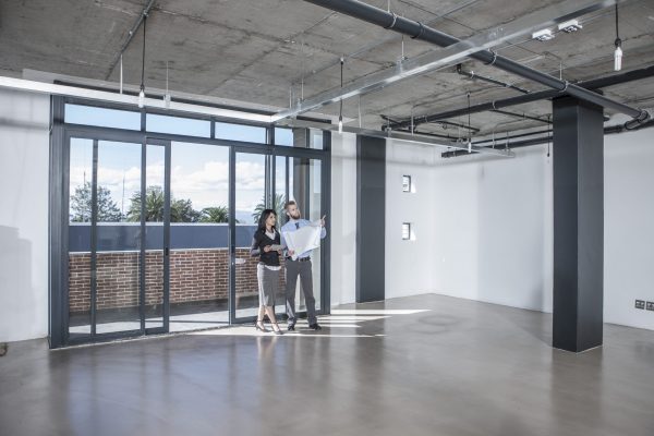 Businesspeople looking at construction plan in new open office